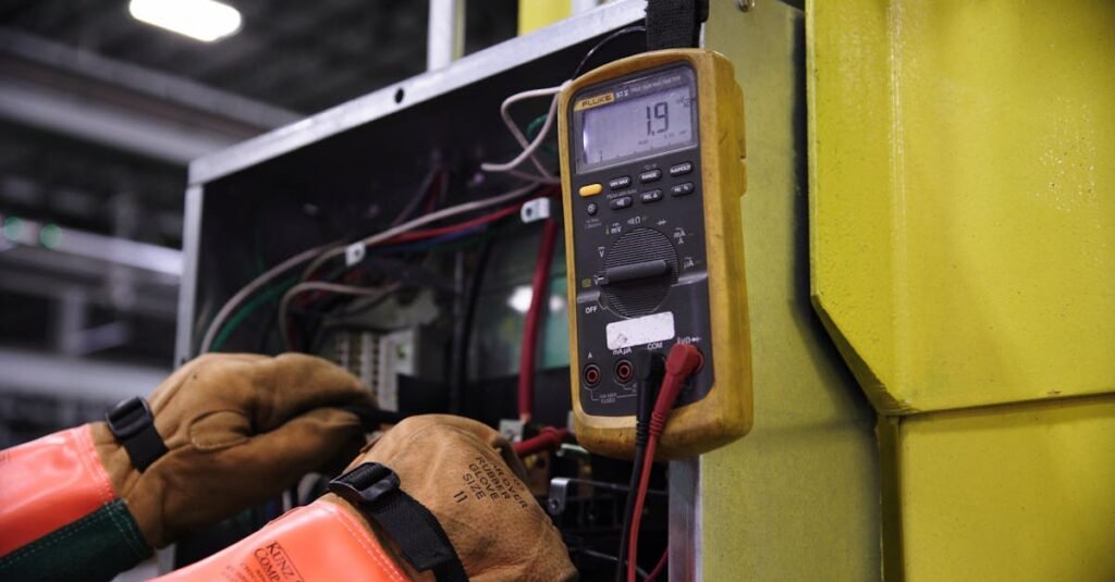 Electrician using a multimeter to fix industrial control panel wiring.