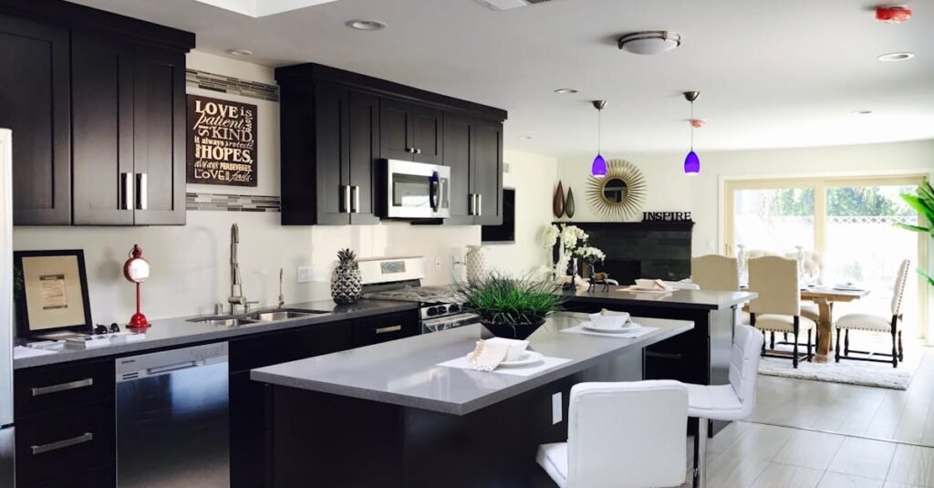 Sleek open-plan kitchen with modern decor, featuring stainless appliances and bar seating.