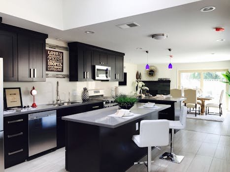 Sleek open-plan kitchen with modern decor, featuring stainless appliances and bar seating.